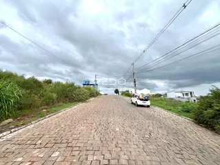 Uma rua pavimentada em Lajeado, Brasil, com vegetação nas laterais.