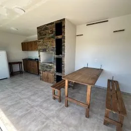 Ambiente interno com parede de pedra aparente e piso claro.