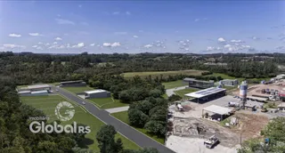 Vista aérea de uma propriedade rural com áreas de mata e infraestrutura industrial.