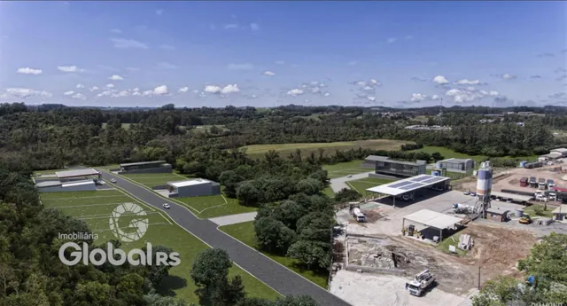 Vista aérea de uma propriedade rural com áreas de mata e infraestrutura industrial.