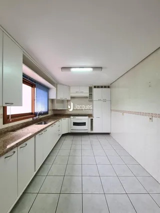 Foto de uma cozinha com armários brancos e piso de cerâmica.