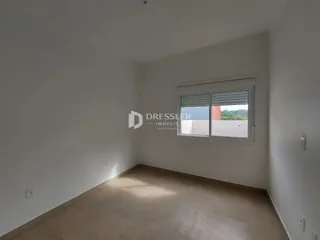 Vista interna de um cômodo com paredes brancas e piso claro.