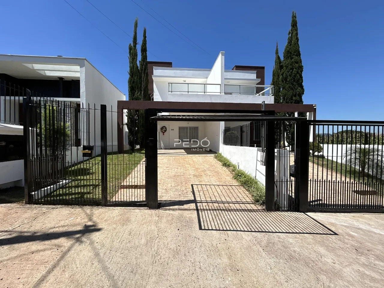 Fachada de uma residência em Lajeado, Brasil, com portão de ferro de entrada.