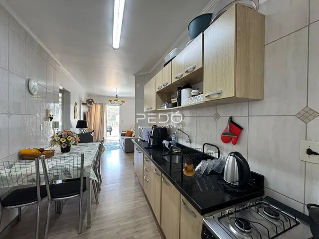Uma cozinha e sala de jantar com piso de madeira clara.