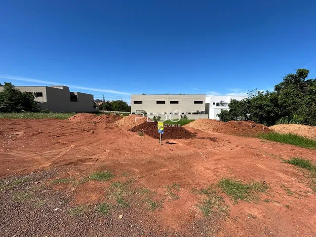 terreno em terra vermelha com construções em construção ao fundo