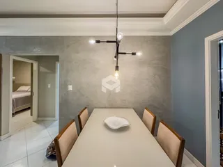 Vista da sala de jantar com mesa e cadeiras em um imóvel.