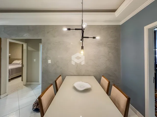 Vista da sala de jantar com mesa e cadeiras em um imóvel.