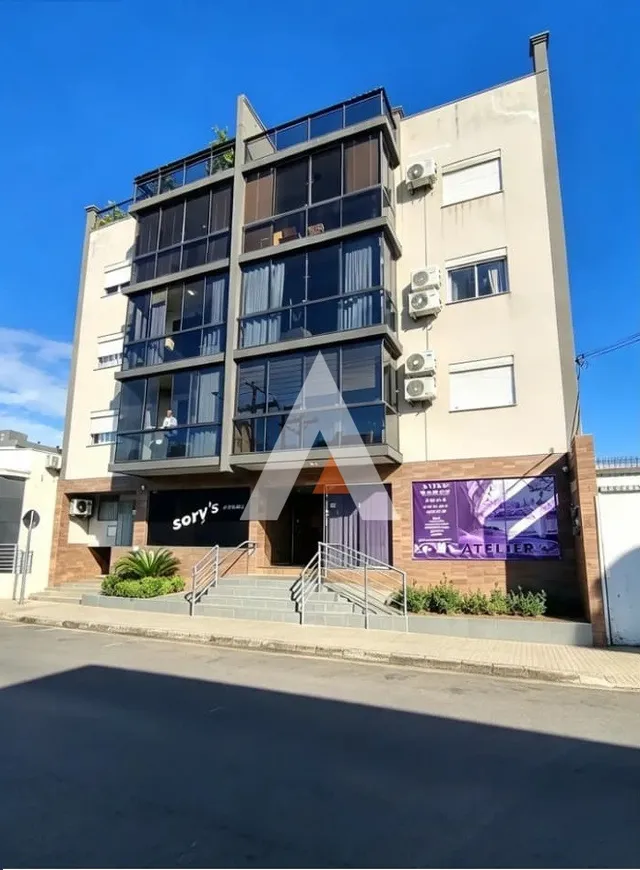 Fachada de um prédio residencial em Lajeado, Brasil, com janelas grandes e varandas.