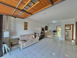 Sala de estar com piso de cerâmica e teto de madeira em imóvel no Brasil.