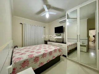 Foto de um quarto com cama e armário de espelho em um imóvel.