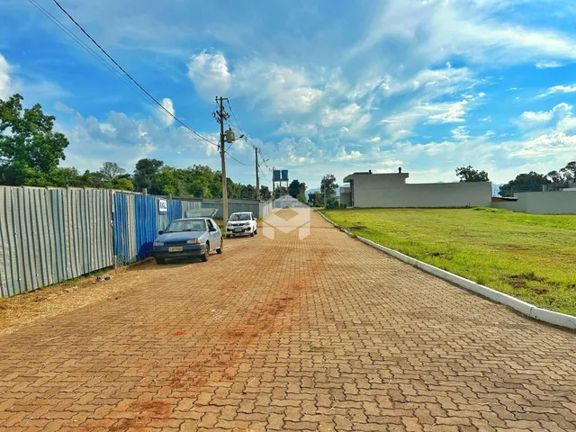 Vista da propriedade com estrada de acesso e campo aberto.