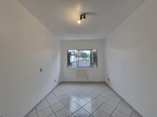 Interior de uma sala com piso de cerâmica e paredes brancas.