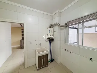 Interior de um cômodo com paredes brancas e piso de cerâmica.
