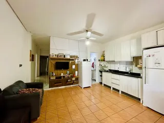 Sala de estar e cozinha com piso de cerâmica no imóvel.