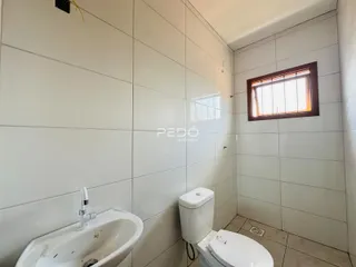 Foto de um banheiro interno com revestimento de azulejos brancos.