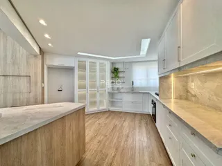 Foto de uma cozinha moderna com armários brancos e piso de madeira clara.