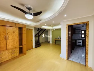 Sala de estar com piso de madeira clara e armários em madeira.