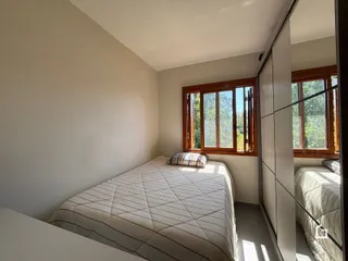 Quarto com cama e janela de madeira em Lajeado.