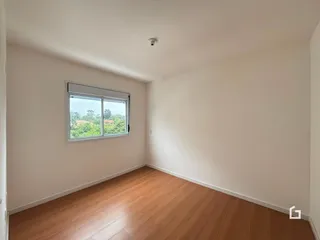 Ambiente interno com piso de madeira e janela.