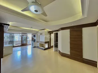 Sala de estar ampla com piso claro e detalhes em madeira.