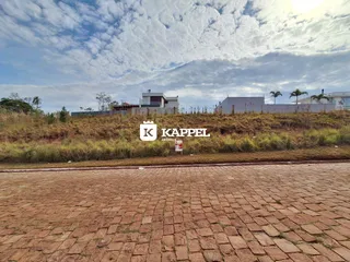 Vista externa de uma propriedade em Lajeado, com vegetação seca e um pátio de tijolos.