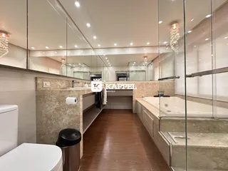 Banheiro com bancada e box de vidro em um imóvel.