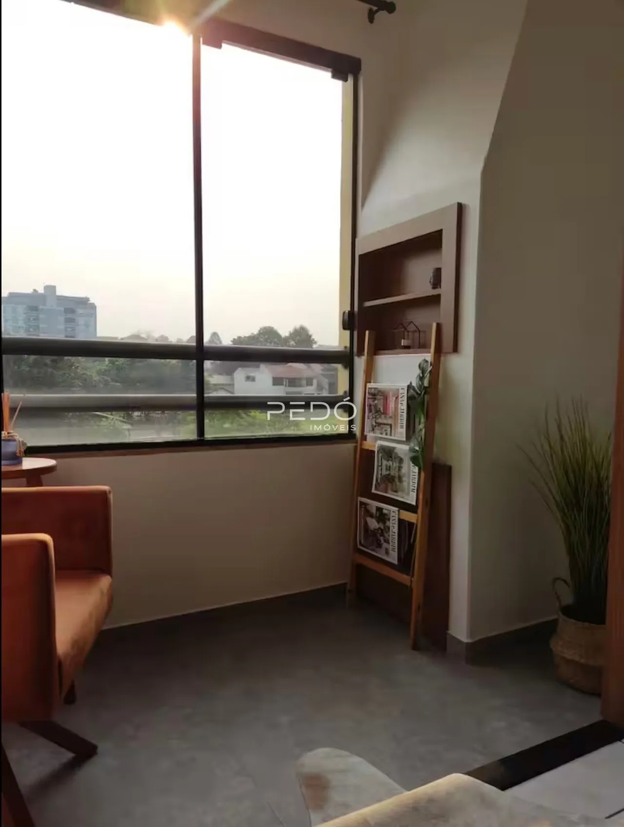 Sala de estar com grande janela de vista para a paisagem.