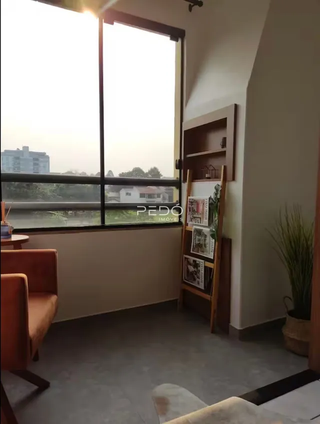 Sala de estar com grande janela de vista para a paisagem.