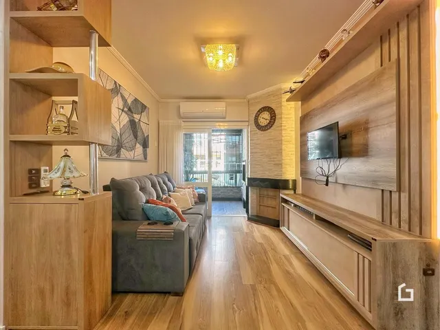 Sala de estar com piso de madeira e lareira em um apartamento.