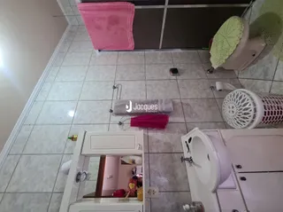 Interior com piso de cerâmica e louças sanitárias brancas.
