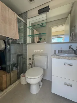 Banheiro moderno com box de vidro e revestimento de cerâmica.