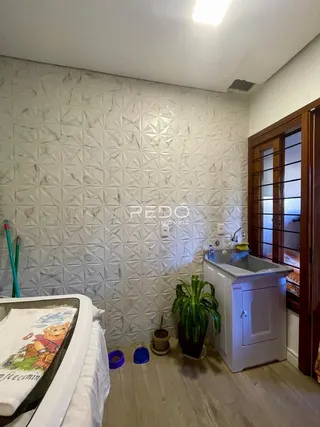 Parede texturizada de um quarto com cama e piso de madeira.
