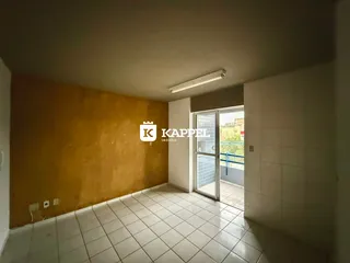 Ambiente interno com piso de cerâmica e parede amarela, com acesso a uma área externa.