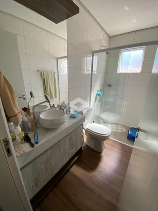 Banheiro moderno com pia e box de vidro.