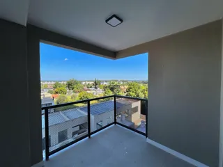 Vista de um terraço com grade de segurança e vista panorâmica da paisagem.