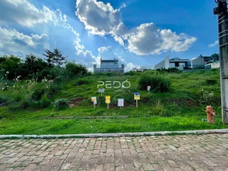 Vista aérea de uma propriedade com terreno gramado e edificações ao fundo.