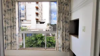 Vista externa de árvores verdes através da janela de uma propriedade em Lajeado.