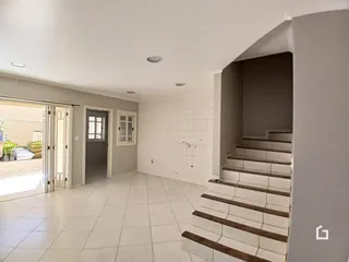Um corredor interno com piso de cerâmica e escadaria visível na propriedade.