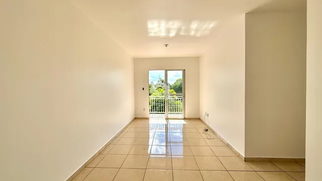 Corredor com piso de cerâmica e portas de vidro para o exterior.