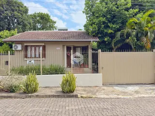 Fachada de uma casa em Lajeado, Brasil, com cerca e jardim na frente.