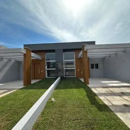 Fachada de uma casa moderna em Lajeado com jardim gramado na frente.