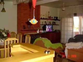 Interior de uma sala com paredes de tijolo e móveis de madeira.