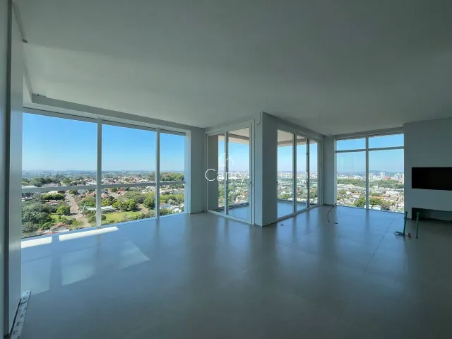 Uma sala ampla com grandes janelas oferece uma vista panorâmica da cidade.