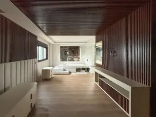 Ambiente interno de uma sala com revestimento de painéis verticais em Lajeado, Brasil.