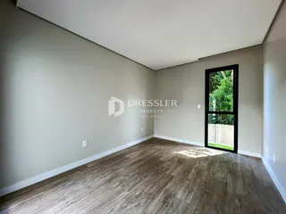 Ambiente interno com piso de madeira clara e paredes neutras.