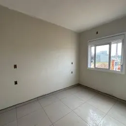 Vista interna de um cômodo com paredes brancas e piso de cerâmica.
