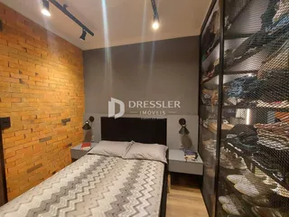 Quarto com parede de madeira e cama em um imóvel no Brasil.