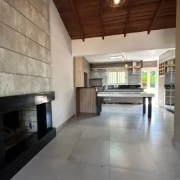 Interior de uma sala com vigas de madeira expostas e lareira.