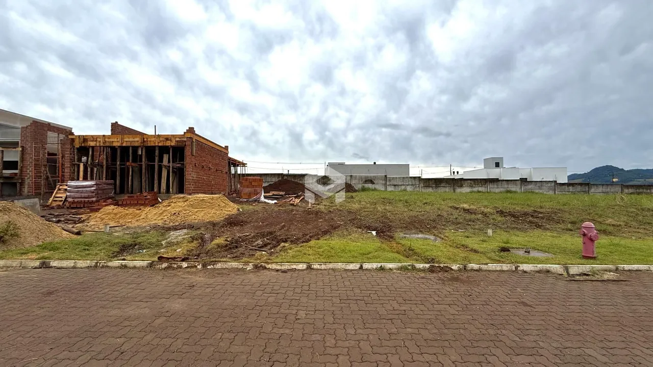 Vista externa de uma construção com paredes de tijolo expostas e terra em Lajeado, Brasil.