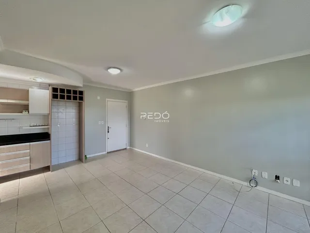 Ambiente interno de uma sala com piso de cerâmica clara e paredes cinzas.